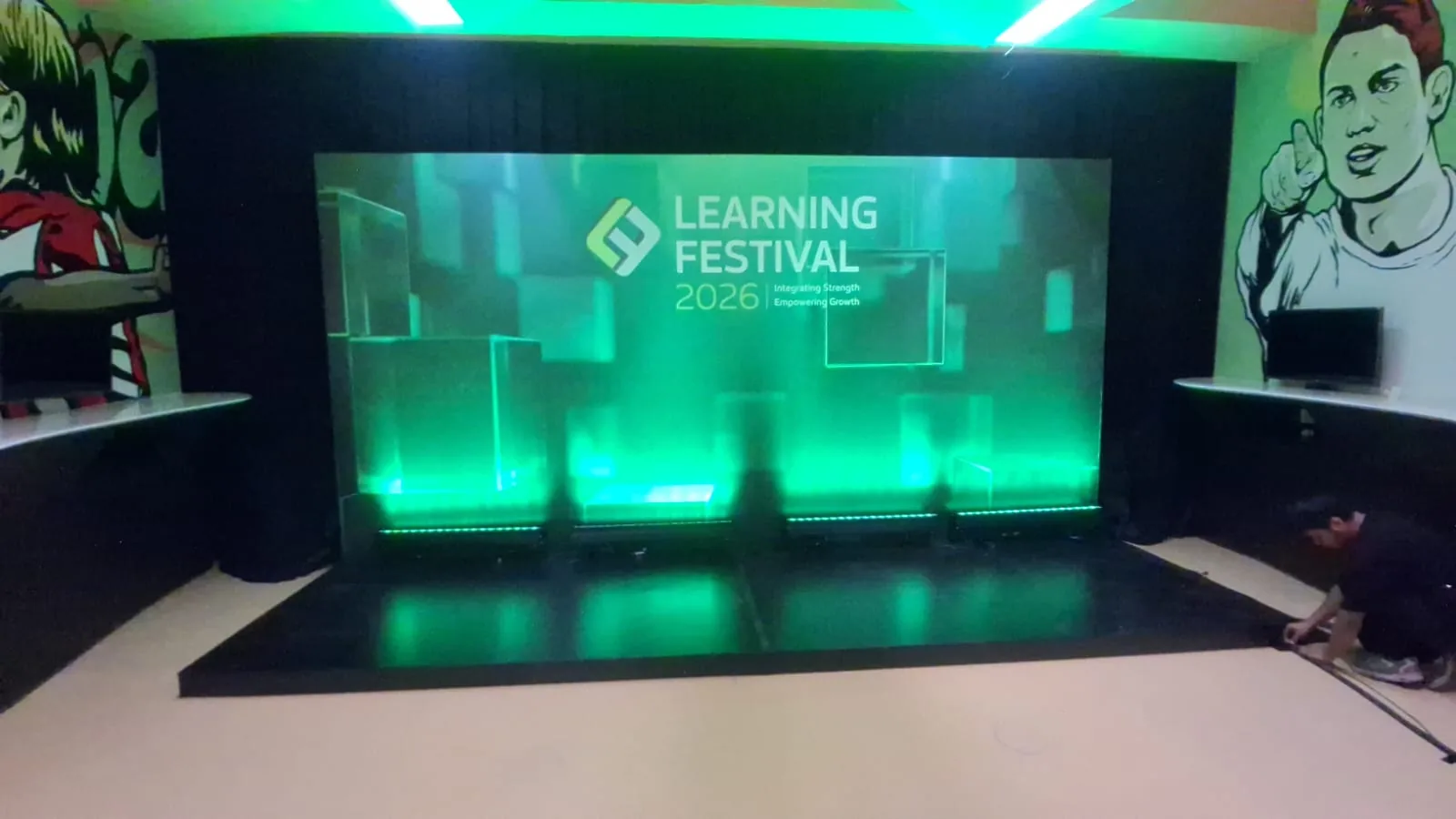 Panggung dengan layar dan lampu uplight hijau di Learning Festival 2026.