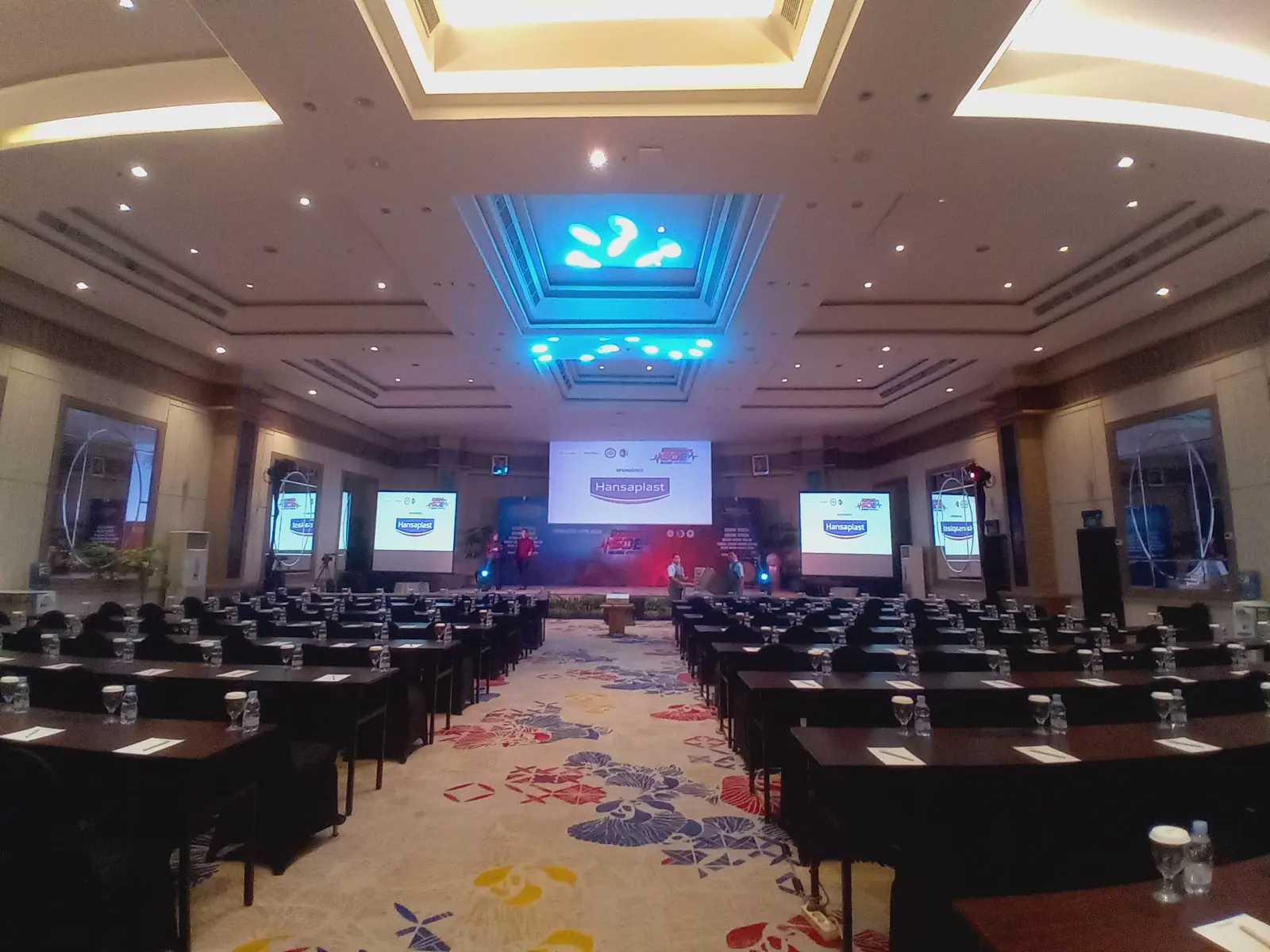 Pencahayaan biru dan meja peserta acara SOE di Hotel Lumire.